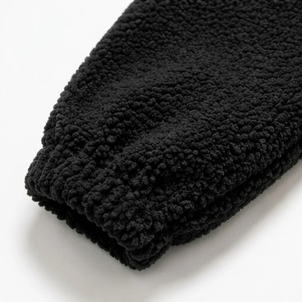 Enzé Midnight Hoodie — Macro cuff detail showing dense curled teddy fleece texture on black heavyweight hoodie