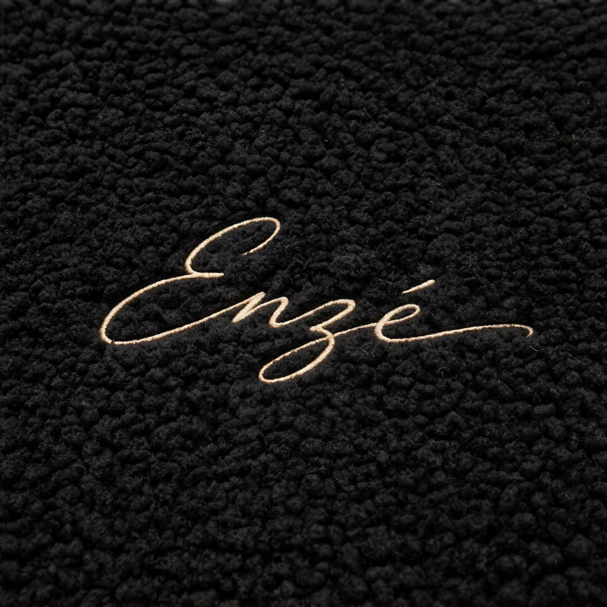 Enzé cream embroidered cursive script logo macro close-up on black heavyweight teddy fleece hoodie