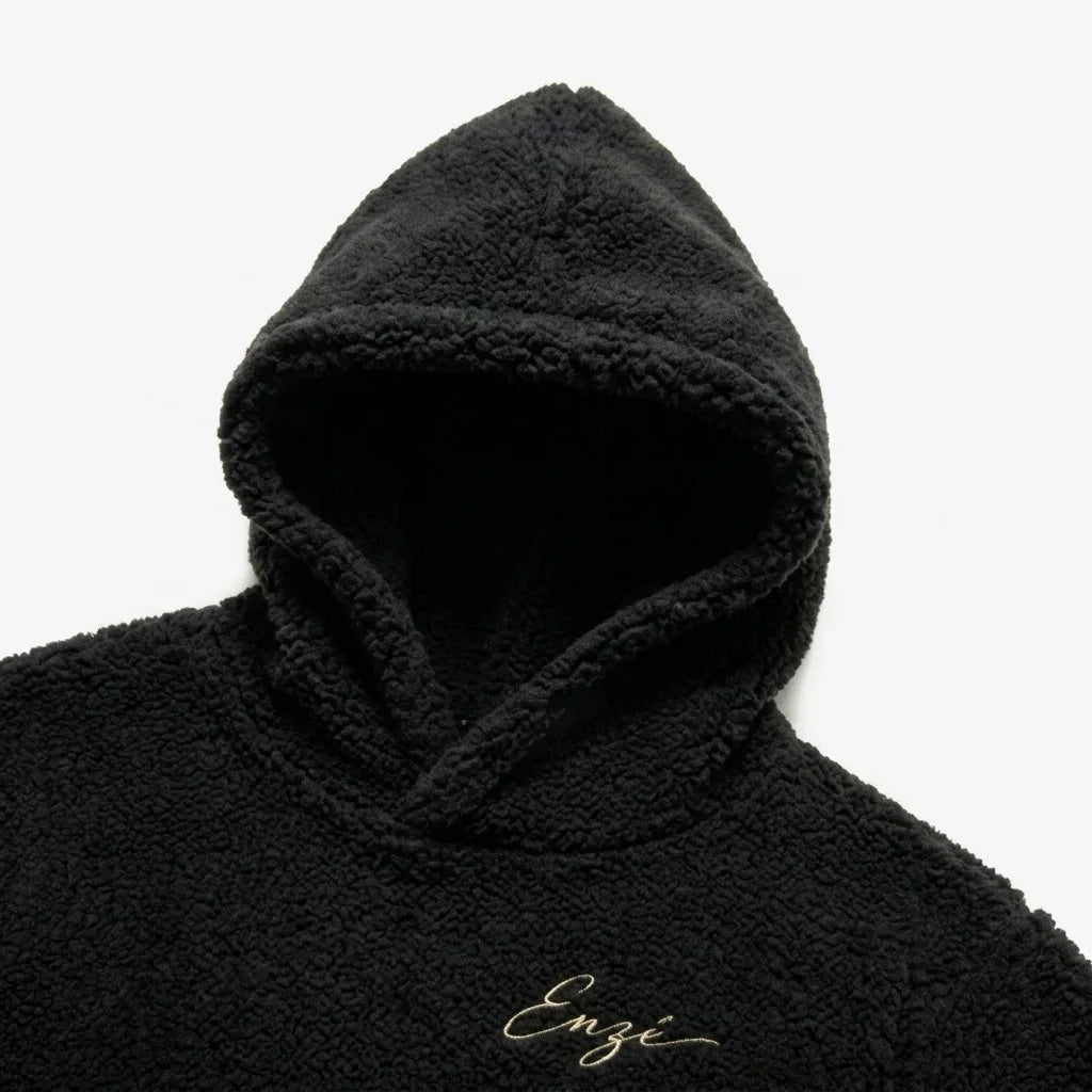 Enzé Midnight Hoodie — Structured hood detail with center seam and cream embroidered script on black heavyweight teddy fleece
